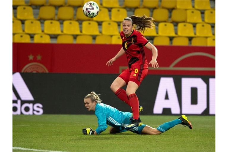 Deutschlands Torfrau Merle Frohms (l) liegt am Boden, während Belgiens Tine De Caigny dem Ball nachschaut. Foto: Federico Gambarini/dpa