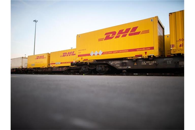 DHL-Container stehen im Güterterminal in Langerfeld auf Waggons. Foto: Jonas Güttler/dpa