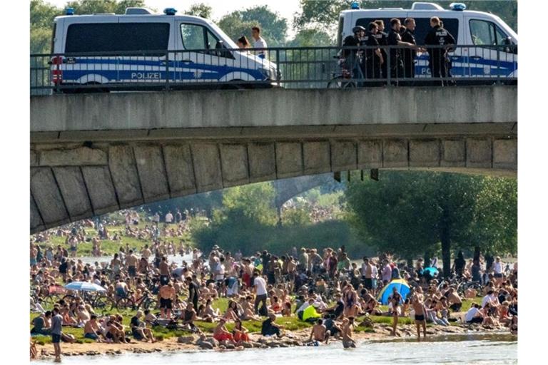 Dicht an dicht liegen die Menschen bei sommerlichen Temperaturen an der Isar. Foto: Peter Kneffel/dpa