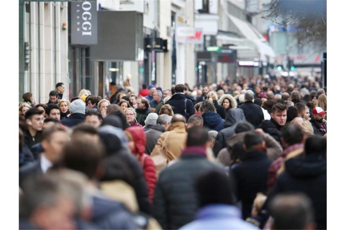 Bevölkerungswachstum in Deutschland schwächt sich ab Dicht gedrängt laufen Menschen über die Königsallee in Düsseldorf. Foto: Martin Gerten/dpa