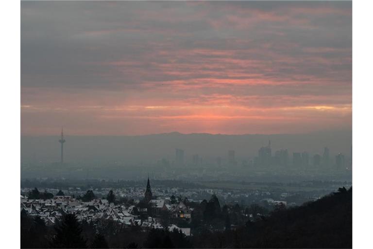 Dichter Hochnebel und Wolken bei Sonnenaufgang über Frankfurt am Main. Foto: Boris Roessler/dpa