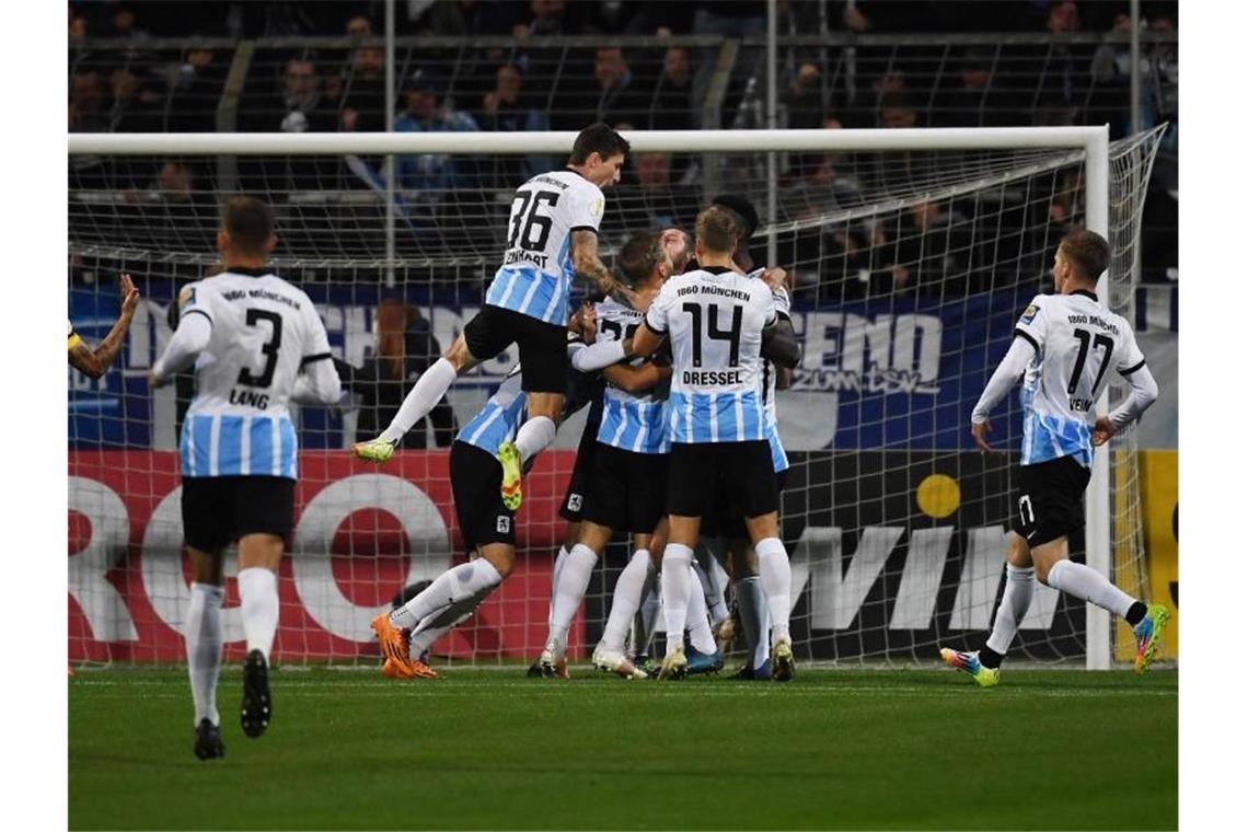Dortmund und Leipzig weiter - Freiburg rettet sich Die 1860-Spieler feiern den Sieg gegen den FC Schalke 04. Foto: Angelika Warmuth/dpa