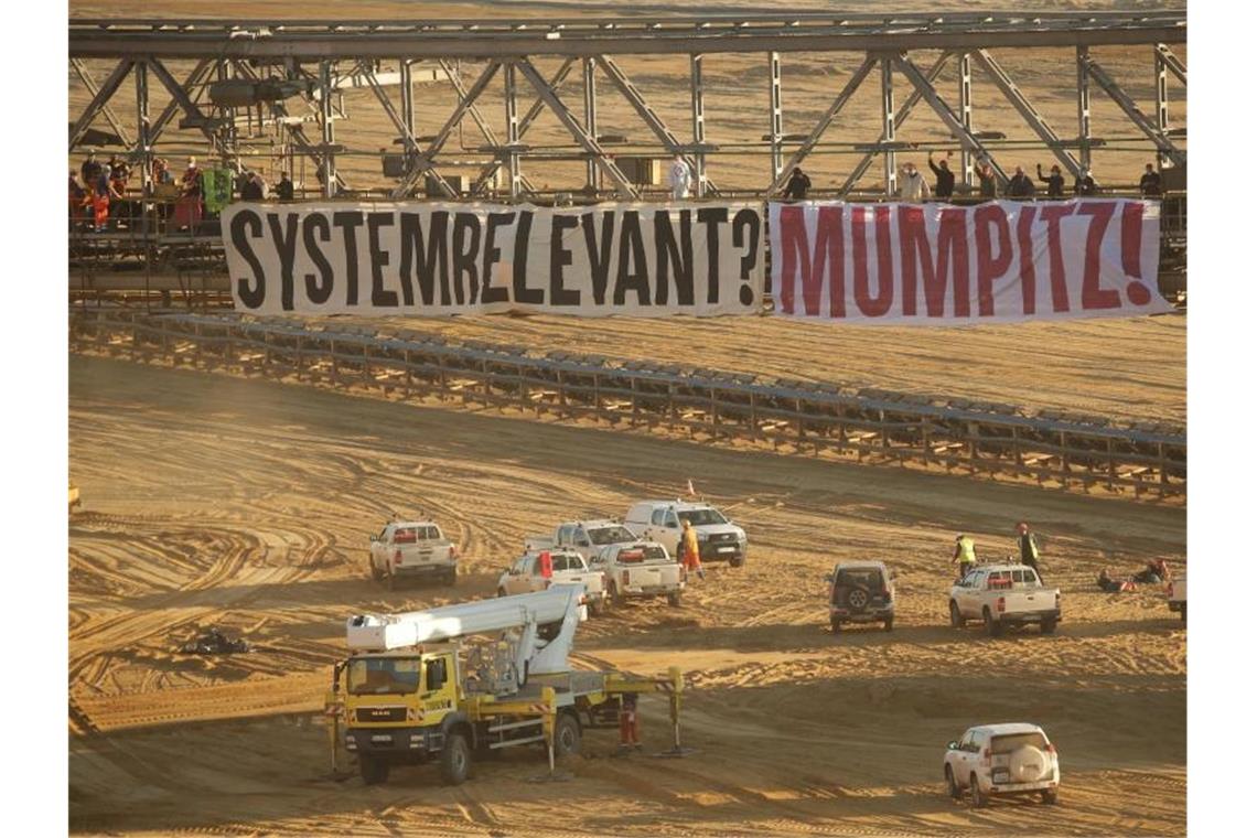 Die Aktivisten demonstrieren gegen die Kohle-Konzerne und die Politik. Foto: David Young/dpa