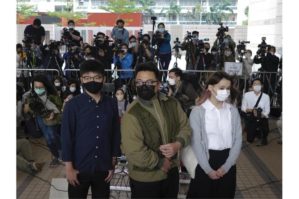 Die Aktivisten Joshua Wong (l-r), Ivan Lam und Agnes Chow stehen vor dem Gerichtsgebäude in Hongkong. Foto: Vincent Yu/AP/dpa
