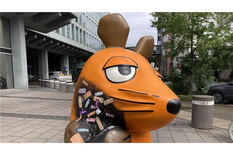 Die angebrannte Maus-Figur wird mit Pflastern versorgt.
