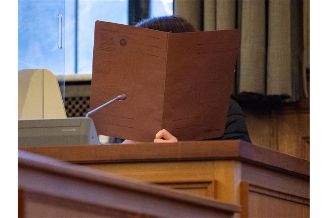 Tod eines Säuglings: Bewährungsstrafe für Mutter Die Angeklagte nimmt an einem Prozess im Schwurgerichtssaal im Landgericht Tübingen teil und hält einen Ordner vor ihr Gesicht. Foto: Marijan Murat/dpa/Bildarchiv