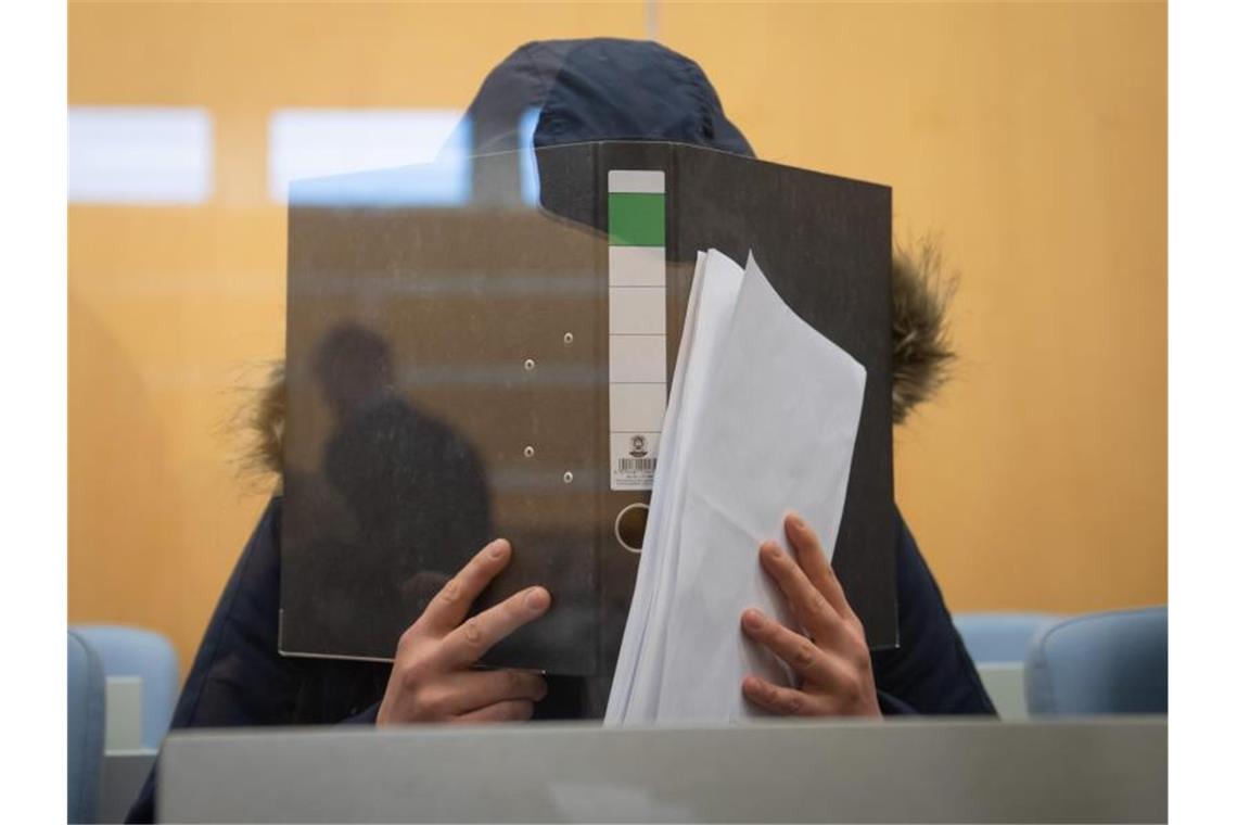 Die Angeklagte verbirgt im Düsseldorfer Oberlandesgericht ihr Gesicht hinter einem Aktenordner. Foto: Bernd Thissen/dpa