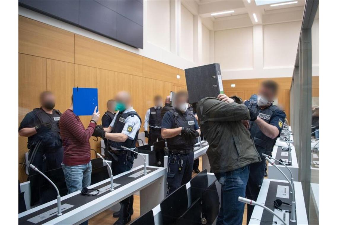 Die Angeklagten werden von Justizbeamten kurz vor Beginn des Prozesses gegen die rechtsterroristische Vereinigung "Gruppe S." in einen Saal im Oberlandesgericht Stuttgart-Stammheim geführt. Foto: -/dpa-pool/dpa