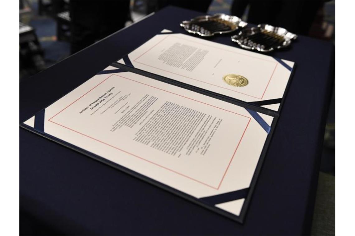 Trump-Impeachment mit Plädoyers fortgesetzt Die Anklagepunkte im Amtsenthebungsverfahren gegen US-Präsident Trump liegen zur Unterzeichnung auf dem Schreibtisch von Nancy Pelosi. Foto: Susan Walsh/AP/dpa