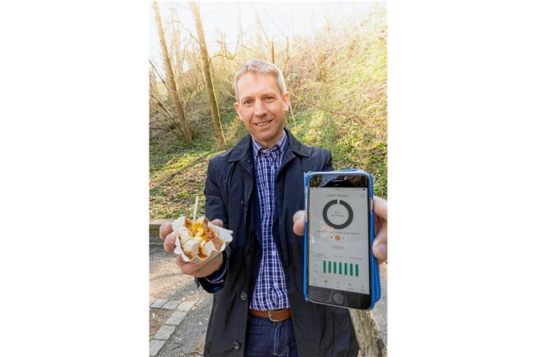 Die App auf dem Handy gibt grünes Licht: Wenn die 16 Fastenstunden vorbei sind, darf sich Redakteur Kornelius Fritz sogar eine Currywurst gönnen. Foto: A. Becher