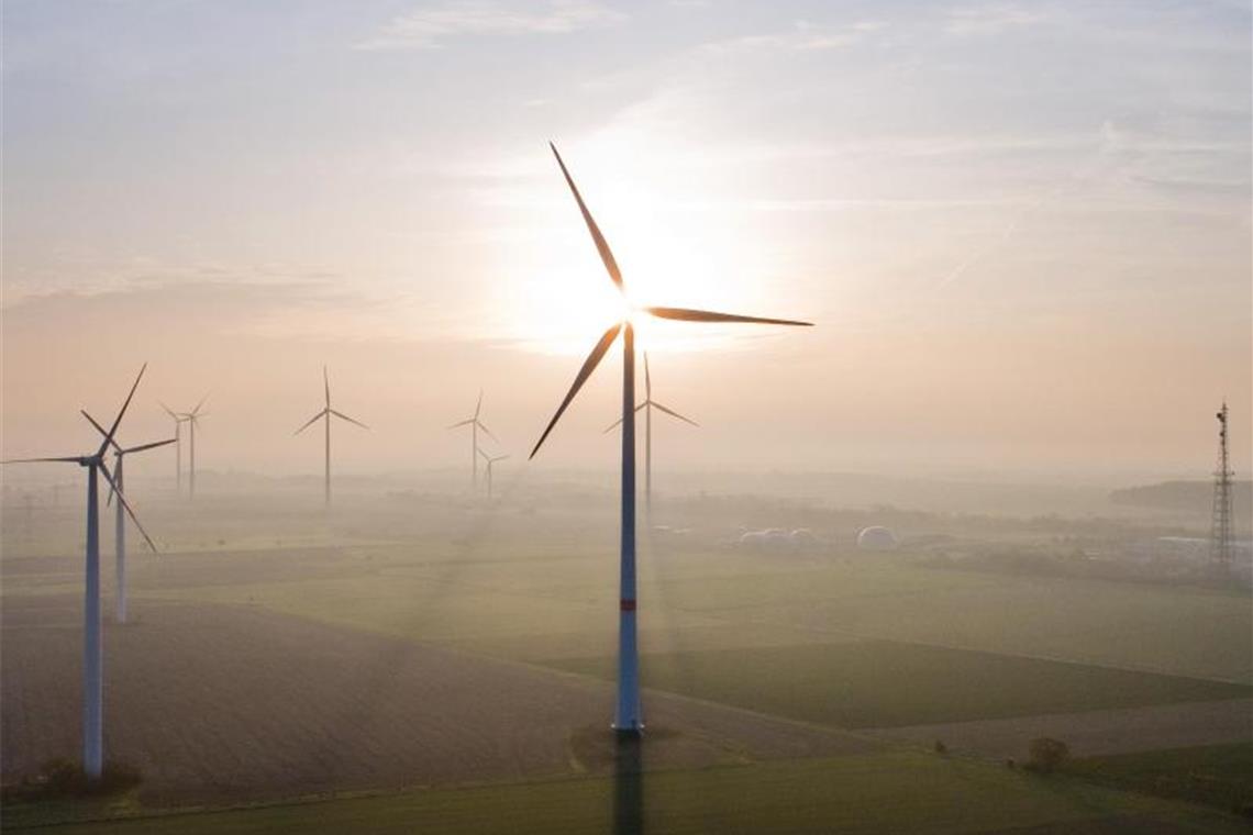 Die aufgehende Sonne steht hinter einem Windrad im Landkreis Peine, Niedersachsen. Foto: Julian Stratenschulte/dpa