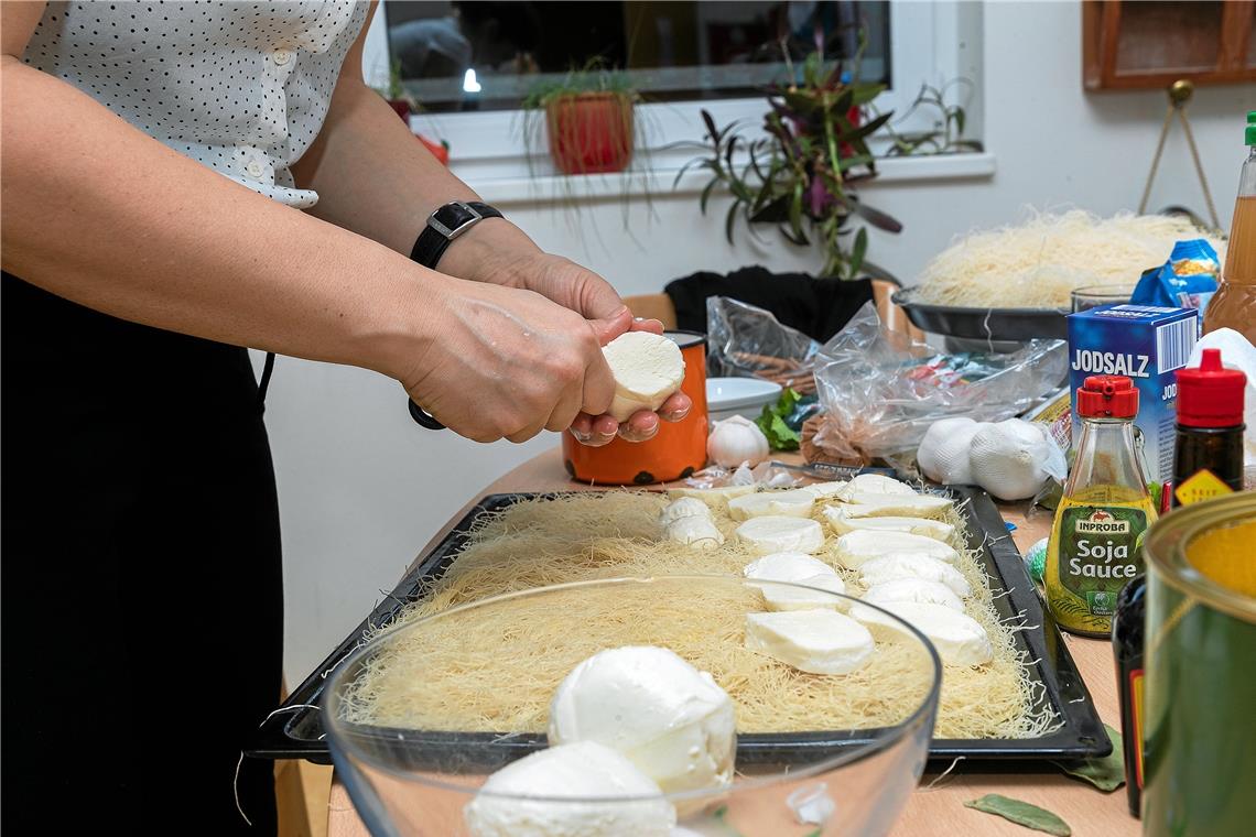 Orientalische Aromen zum Fest Die auseinandergezogenen Teigfäden werden mit Mozzarellascheiben belegt. Dann kommt noch eine Schicht Teigfäden darüber. Alles zusammen wird satt mit Zuckersoße und Ghee begossen.