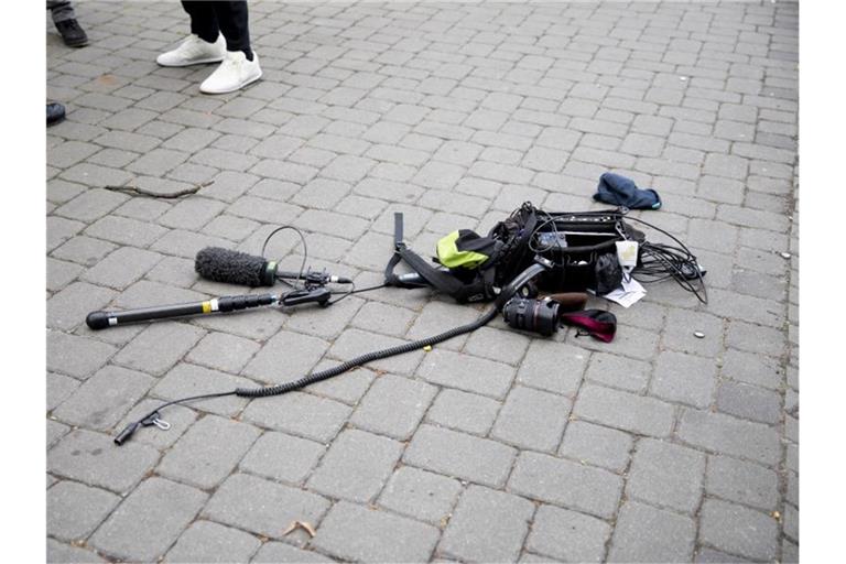 Die Ausrüstung des Kamerateams liegt nach der Attacke auf dem Boden. Foto: Christoph Soeder/dpa