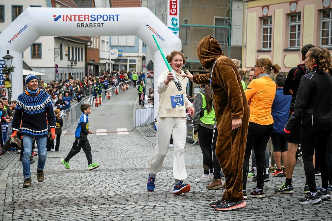 36. Backnanger Silvesterlauf: Der Spaß steht über dem sportlichen Erfolg Die Backnanger Bürgerbühne sorgt für einen Hauch Star Wars. Juliane Putzmann als Prinzessin Leia übergibt den Stab an Gerhard Kleesattel als Chewbacca. Foto: Alexander Becher