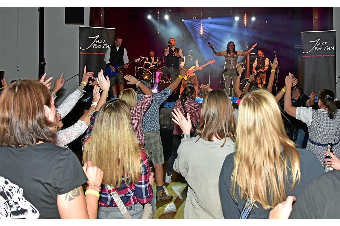 Die Band auf der Bühne heizt die Stimmung an. Zünftige Stimmung auf der Party Bi...