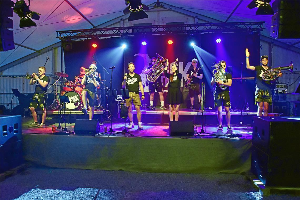 Die Band Bockstark steht mit Blasinstrumenten auf der Bühne.