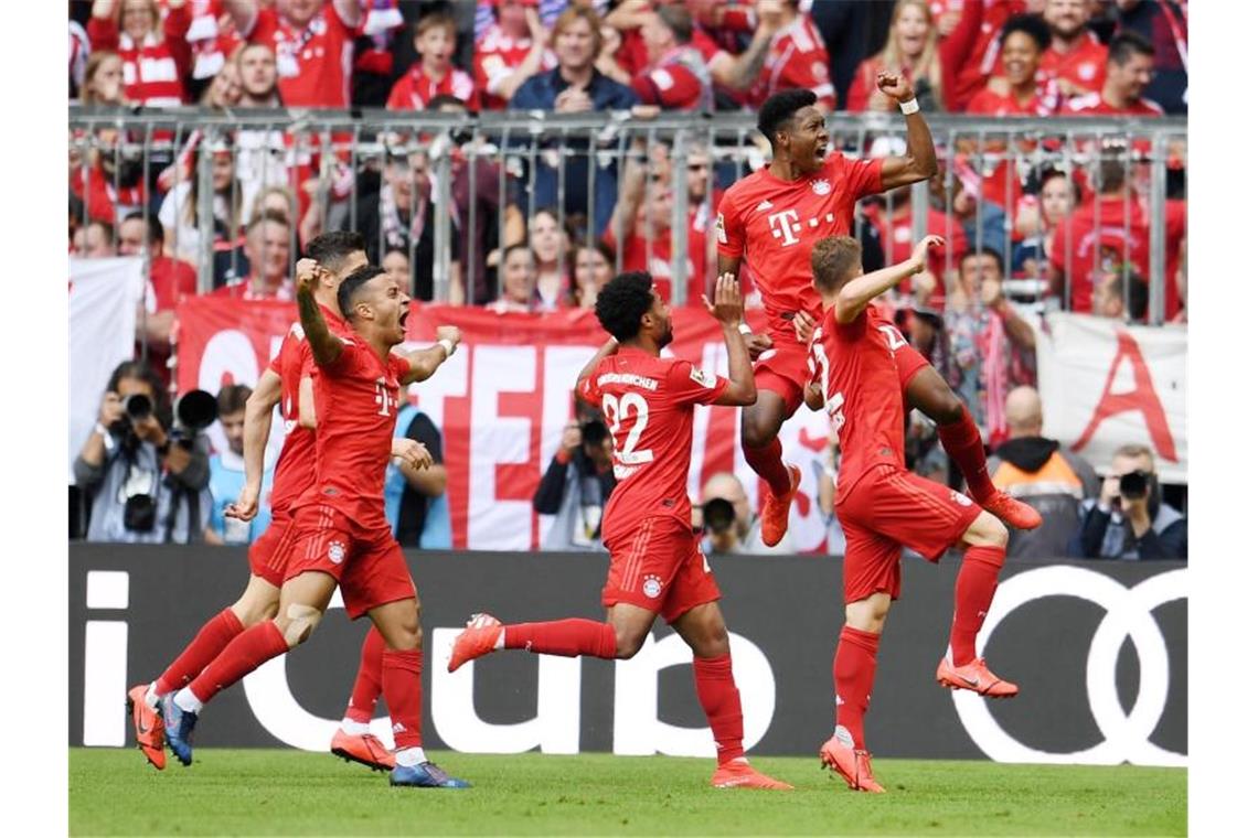 Die Bayern-Spieler feiern das vorentscheidende 2:1 von David Alaba gegen Eintracht Frankfurt. Foto: Tobias Hase