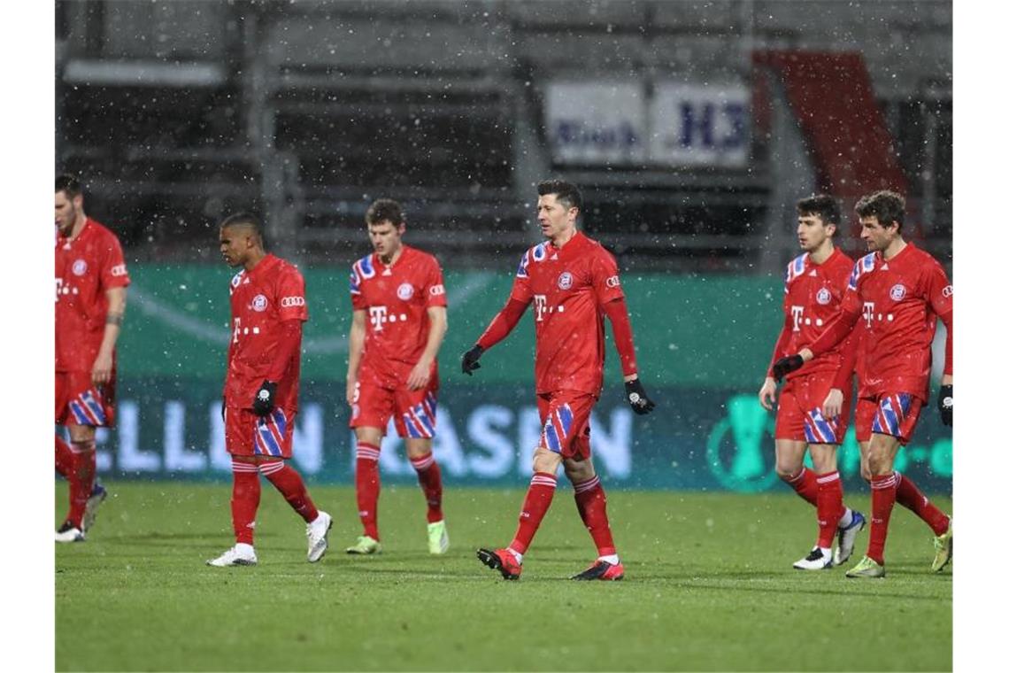 Die Bayern-Spieler verlassen nach dem Pokal-Aus in Kiel frustriert den Rasen. Foto: Christian Charisius/dpa