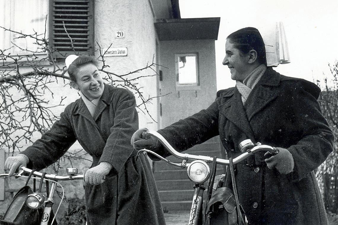 Pioniere der Pflege in Murrhardt Die beiden Gemeindeschwestern Hanne Fetzer und Meta Wörner (von links), die mit Fahrrädern unterwegs waren, 1964 vor dem Aufgang zur Schwesternstation. Das modernisierte Gebäude ist heute der Sitz von Diakonie ambulant. Fotos: Diakoneo/Diak-Archiv Schwäbisch Hall
