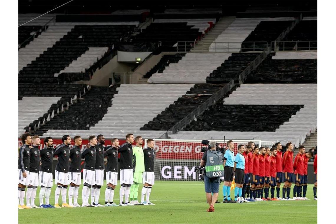 Die beiden Teams lauschen vor Spielbeginn vor leeren Rängen in Stuttgart den Nationalhymnen. Foto: Christian Charisius/dpa