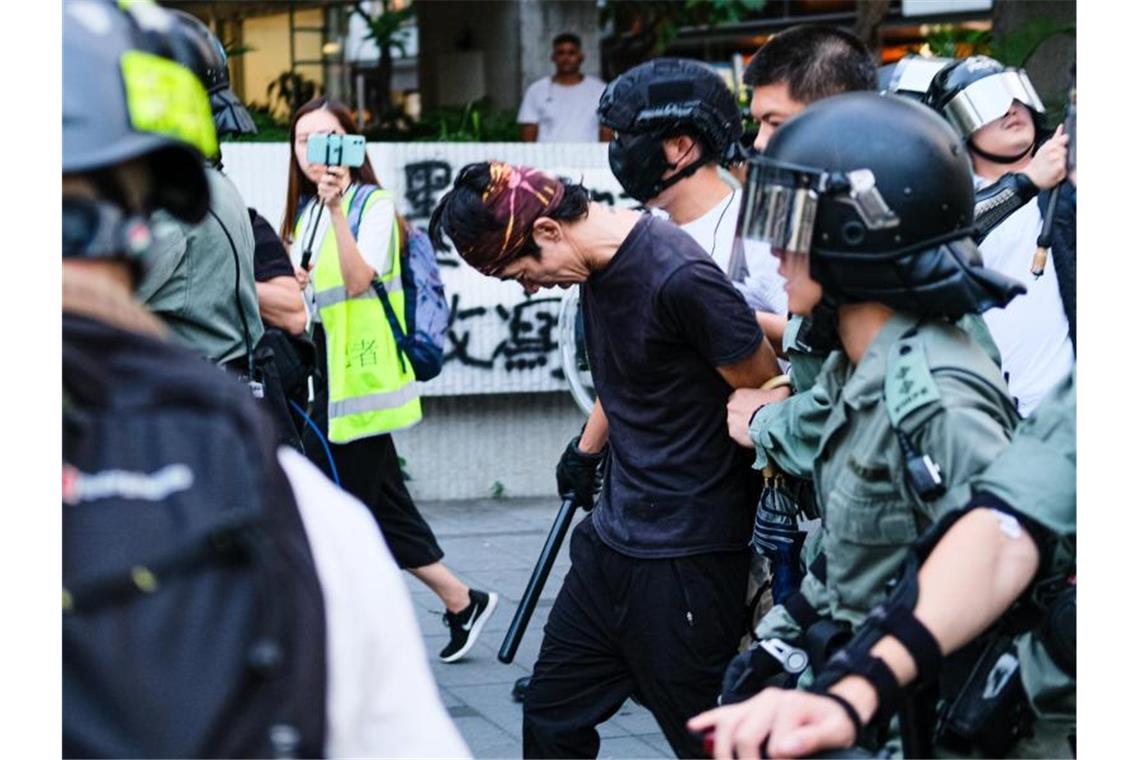 Die Bereitschaftspolizei führt einen Mann ab. Foto: Keith Tsuji/ZUMA Wire/dpa