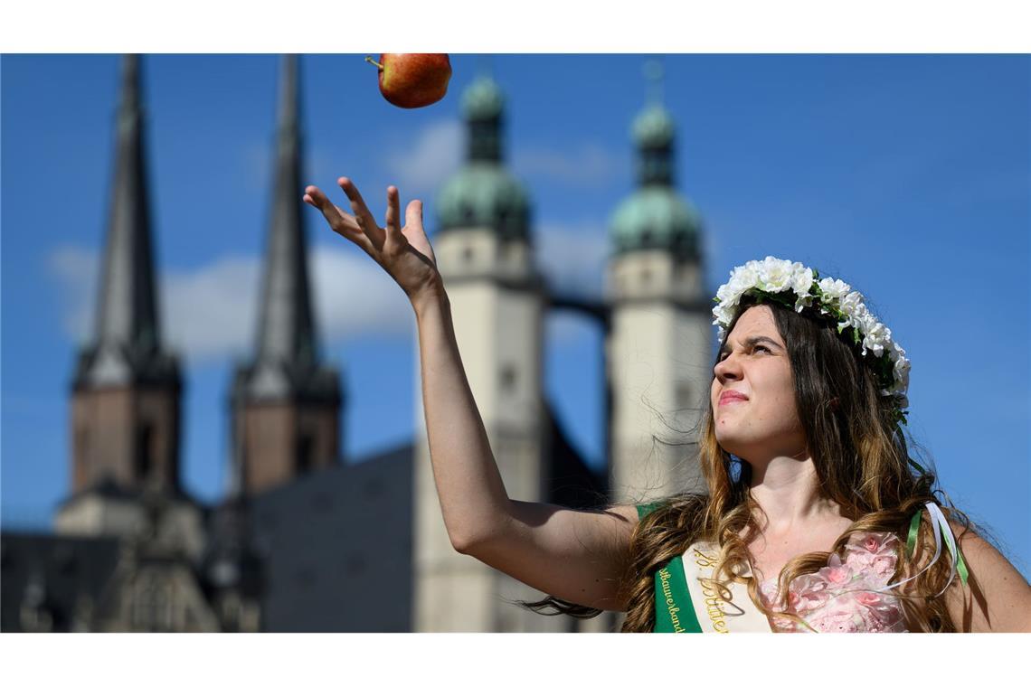 Die Blütenkönigin Alida I. jongliert mit einem Apfel zu Eröffnung der Apfelsaison in Halle (Saale).