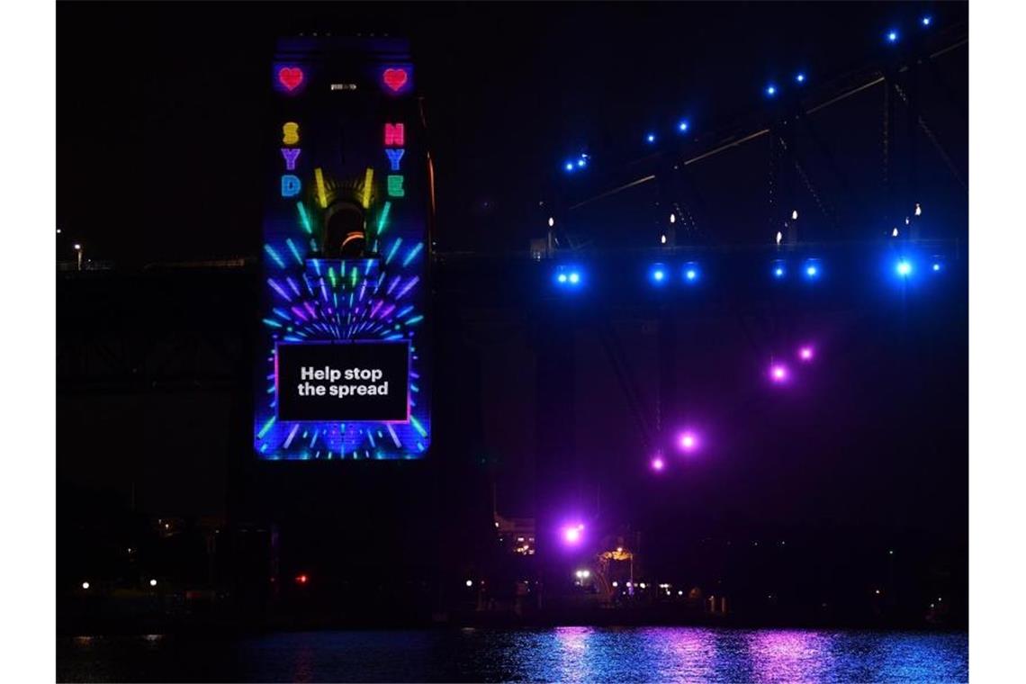 Teile der Welt schon im Jahr 2021 Die Botschaft an der Harbour Bridge in Sydney ist eindeutig: Helfen Sie die Übertragung zu stoppen. Foto: Dean Lewins/AAP/dpa