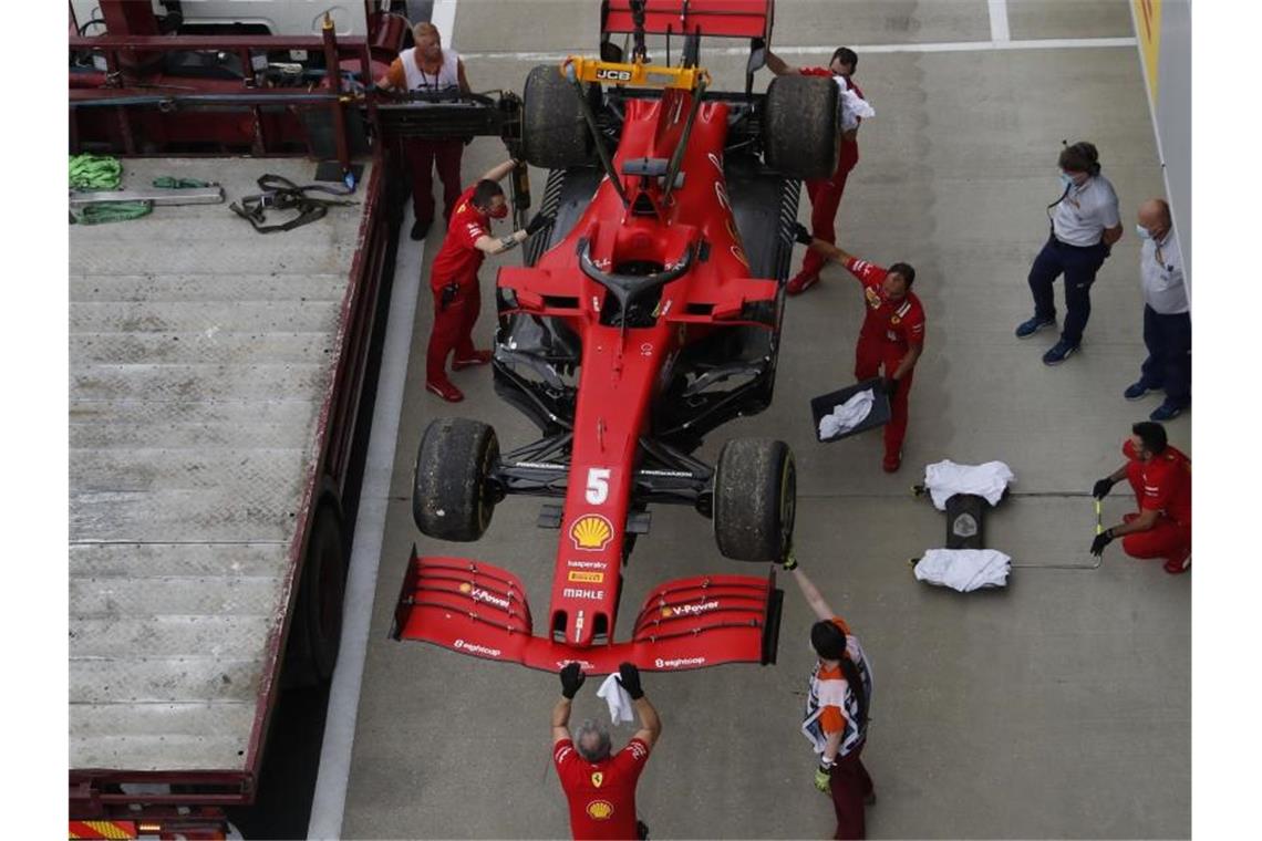 Die Boxenmannschaft von der Scuderia Ferrari überprüft am Ende des Trainings den Wagen von Sebastian Vettel. Foto: Frank Augstein/Pool AP/dpa
