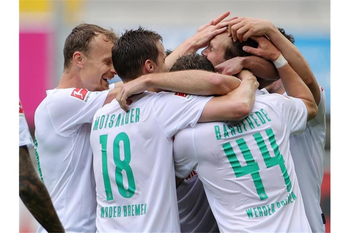 Die Bremer Spieler feiern den 5:1-Sieg in Paderborn. Foto: Friedemann Vogel/EPA/Pool/dpa