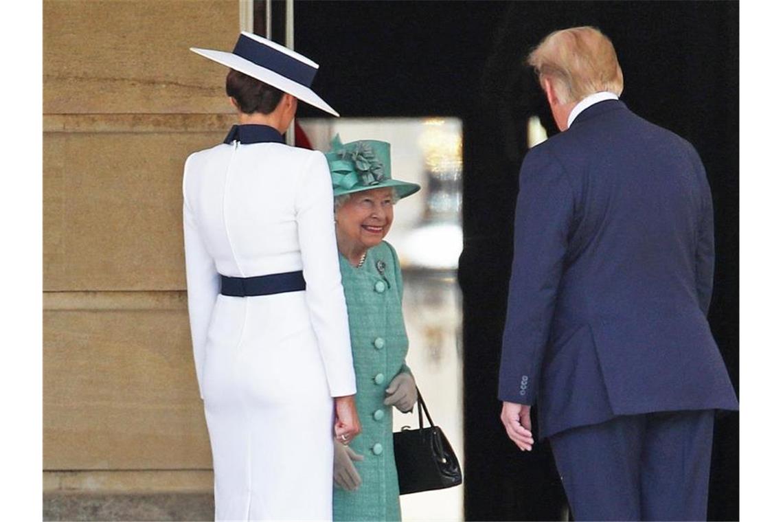 Die britische Königin Elizabeth II. (M) begrüßt Donald Trump (r) und seine Frau Melania Trump im Buckingham Palace. Foto: Yui Mok/PA Wire