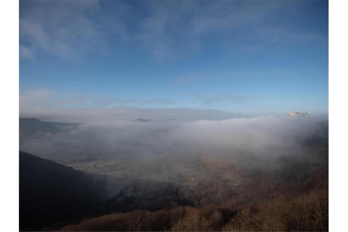 Wetter im Südwesten: Sonne und Regen am Wochenende Die Burgruine Hohenneuffen ist über dem davorliegenden nebelbedeckten Tal zu sehen. Foto: Marijan Murat/dpa/Archivbild