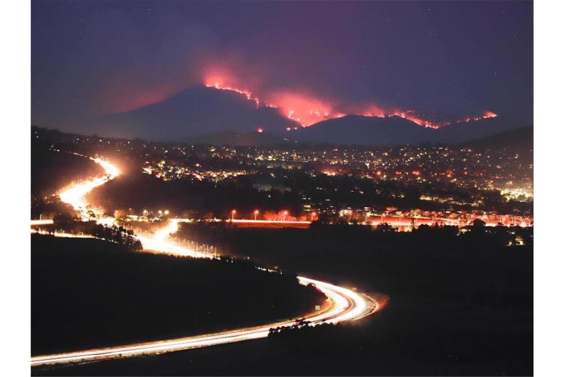 Die Buschfeuer im Orroral Valley südlich von Canberra leuchten in der Dunkelheit in den Hügeln. Foto: Liu Changchang/XinHua/dpa