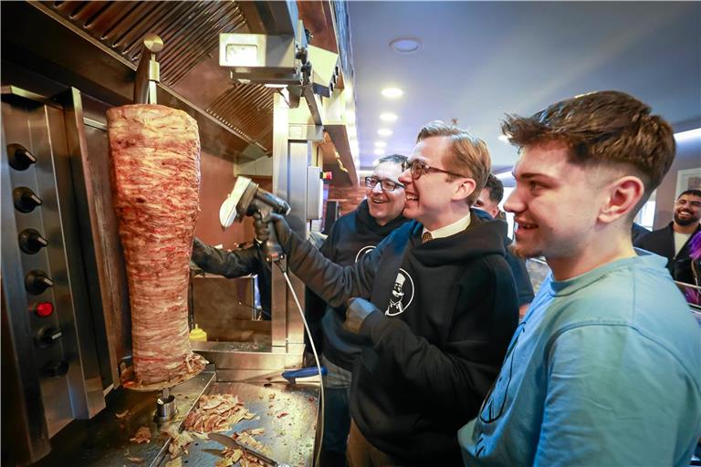 Die CDU-Politiker Philipp Amthor (Mitte) und Jens Steinat (links) dürfen unter der Aufsicht von Gabriel Anilan bei „Onkel Ali“ in Backnang bei der Dönerzubereitung helfen. Foto: Alexander Becher