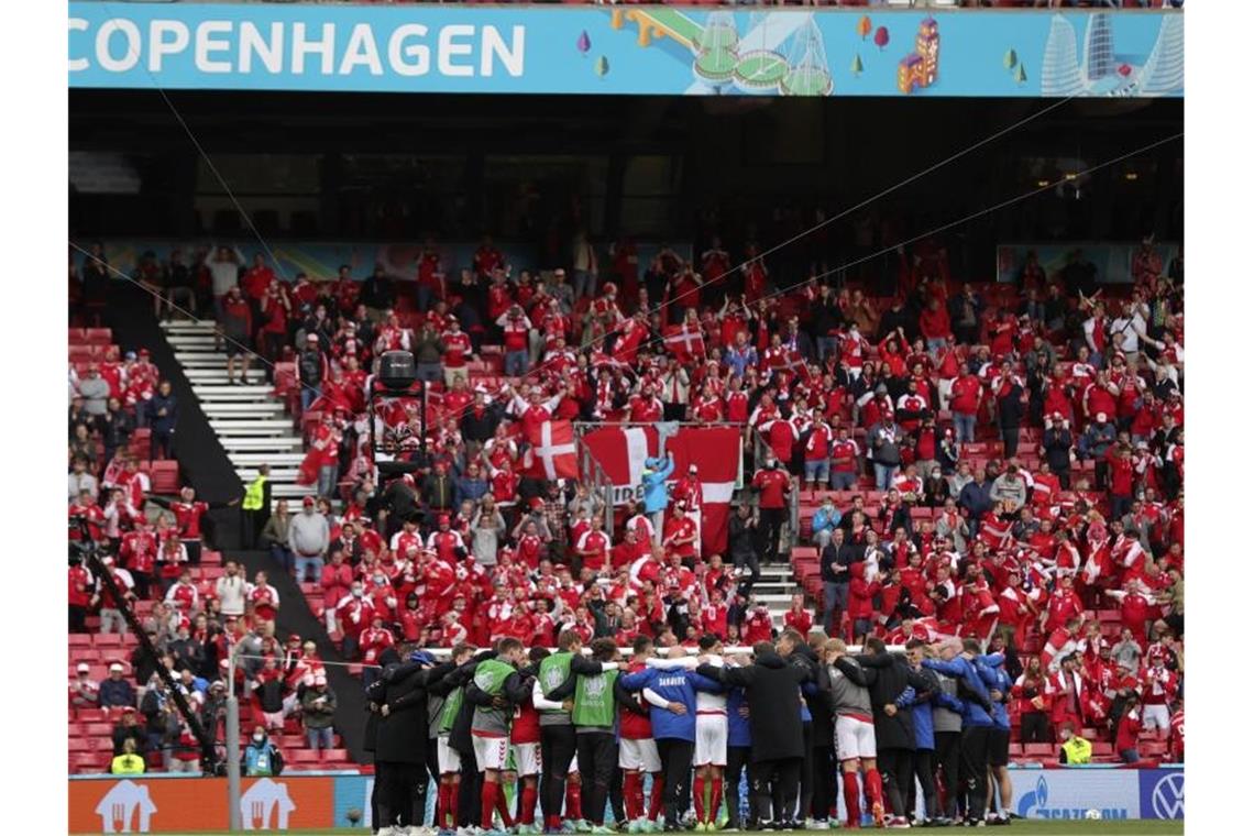 Die dänische Mannschaft schwört sich vor dem Wiederanpfiff ein. Foto: Friedemann Vogel/POOL EPA/AP/dpa