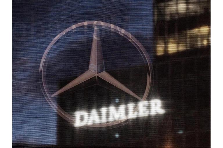 Die Daimler-Zentrale in Stuttgart ist durch eine Flagge zu sehen, auf der der Mercedes-Stern abegebildet ist. Foto: Marijan Murat/dpa