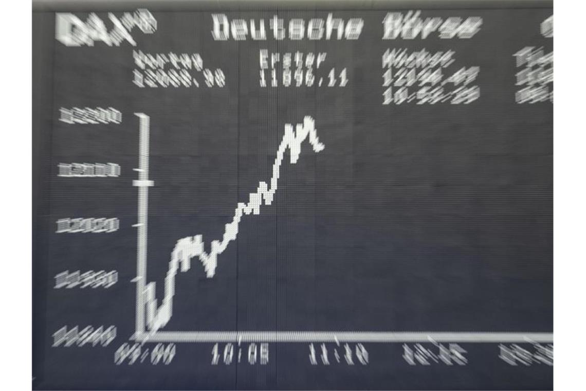 Börsen im Höhenrausch: Jubel oder gefährliche Blase? Die Dax-Kurve wird im Handelssaal der Frankfurter Börse auf der großen Tafel angezeigt. Foto: Frank Rumpenhorst/dpa