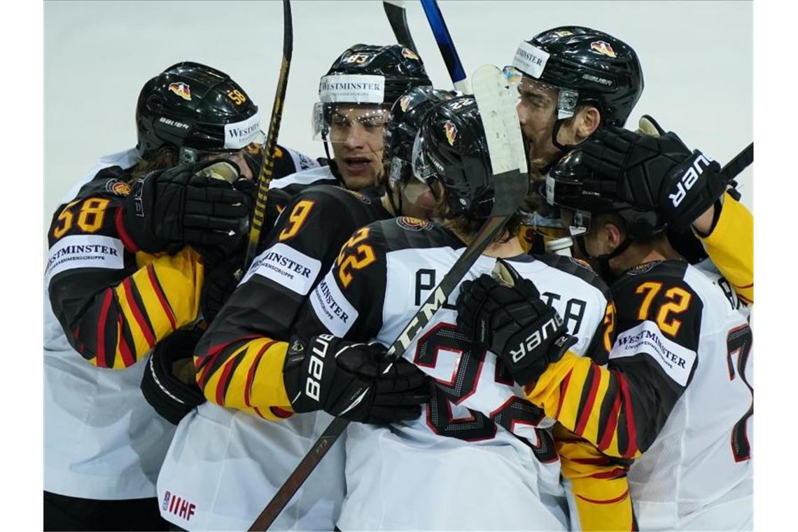 Dank „Briefmarken-Tor“: DEB-Team im Halbfinale Die deutsche Eishockey-Nationalmannschaft feiert den Einzug ins Halbfinale. Foto: Roman Koksarov/dpa