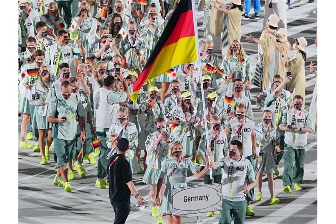 Keine Zuschauer, kein Flair: Olympia beginnt unspektakulär Die deutsche Mannschaft kommt angeführt von Wasserspringer Patrick Hausding und Beachvolleyballerin Laura Ludwig ins Stadion. Foto: Michael Kappeler/dpa
