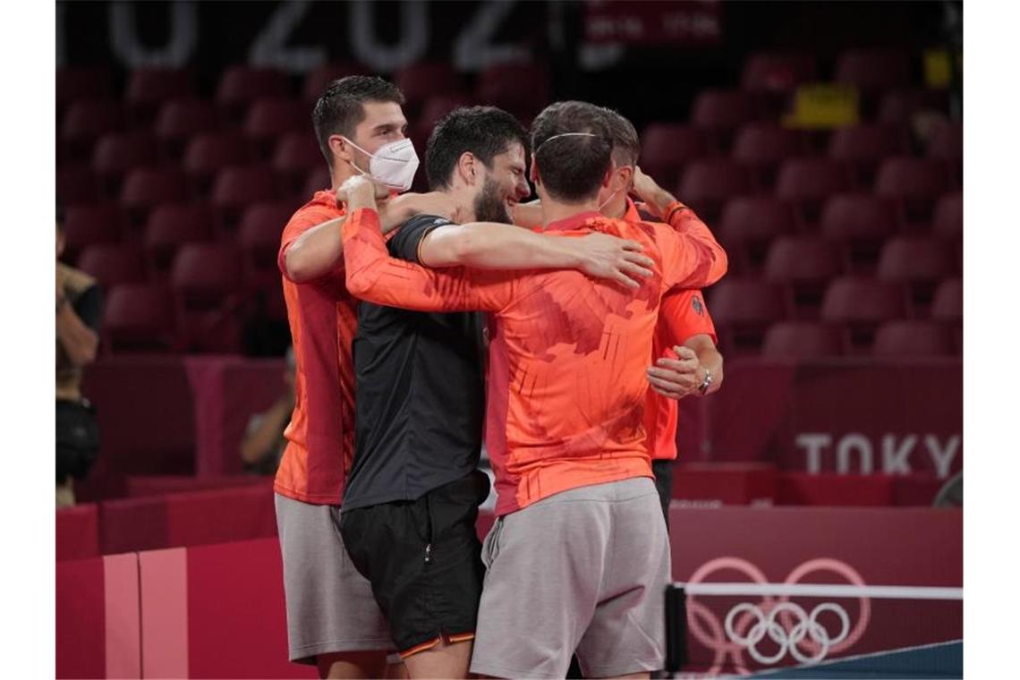 „Sind noch nicht fertig“: Tischtennis-Männer spielen um Gold Die deutsche Mannschaft liegt sich nach dem gewonnenen Halbfinale in den Armen. Foto: Kin Cheung/AP/dpa