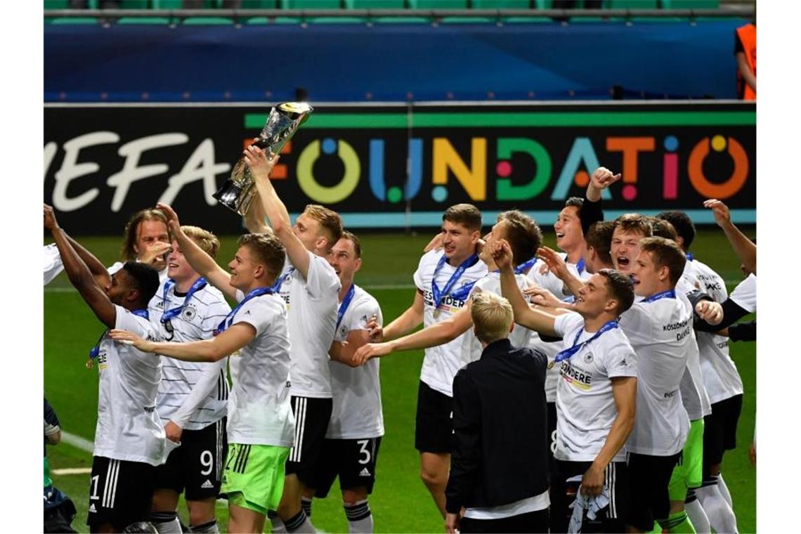 Die deutsche Spieler feiern nach dem Finalsieg mit der Trophäe. Foto: Marton Monus/dpa