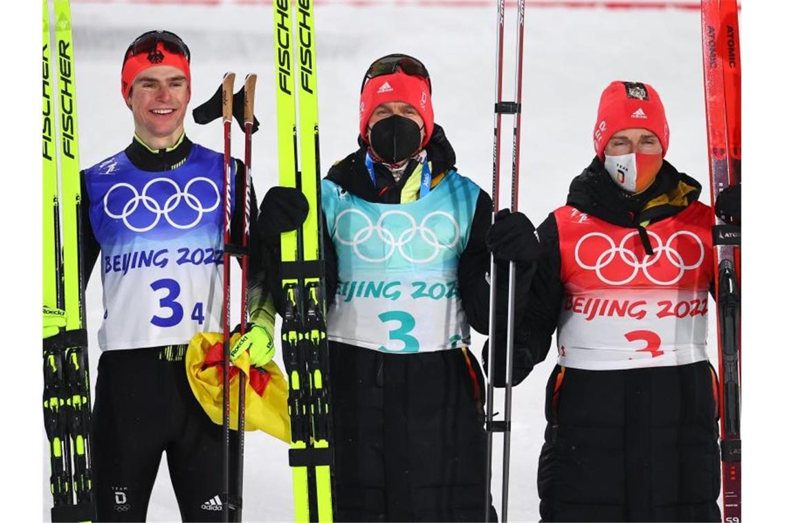 Frenzel fehlt beim Jubeln: DSV-Kombinierer gewinnen Silber Die deutschen Nordischen Kombinierer Vinzenz Geiger (l-r), Julian Schmid und Manuel Faisst jubeln über die Silbermedaille. Foto: Daniel Karmann/dpa