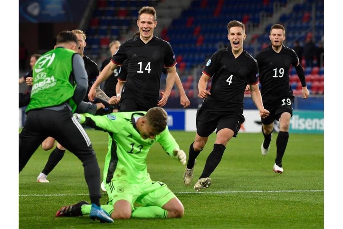 Die deutschen Spieler stürmen nach dem Sieg auf Torhüter Finn Dahmen zu. Foto: Marton Monus/dpa