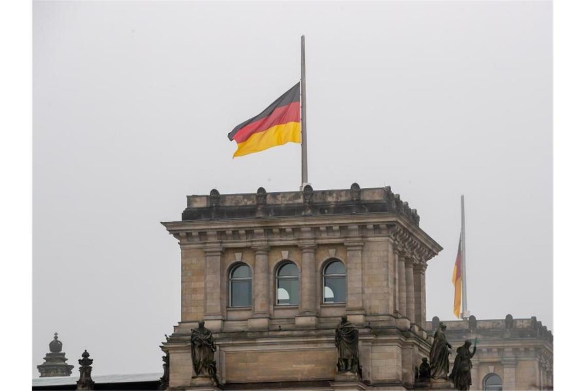 Trauer um fast 80.000 Corona-Tote Die Deutschlandflagge auf dem Reichstagsgebäude weht auf halbmast. Foto: Christoph Soeder/dpa