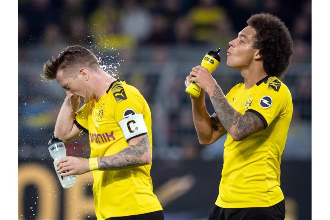 Die Dortmunder Marco Reus (l) und Axel Witsel erfrischen sich nach der Partie gegen den SV Werder Bremen. Foto: Bernd Thissen