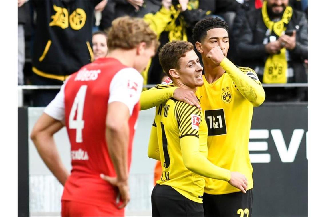 Die Dortmunder Thorgan Hazard (M) und Jude Bellingham bejubeln das Führungstor gegen Köln. Foto: Bernd Thissen/dpa