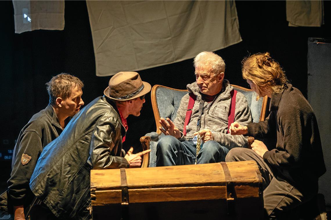 Die drei Räuber (gespielt von Thilo Gaiser, Richie Kanke und – nur in der Probe – Juliane Putzmann, von links) präsentieren ihrem Räuberchef (Dieter Schüle, im Sessel) ihre Beute.
