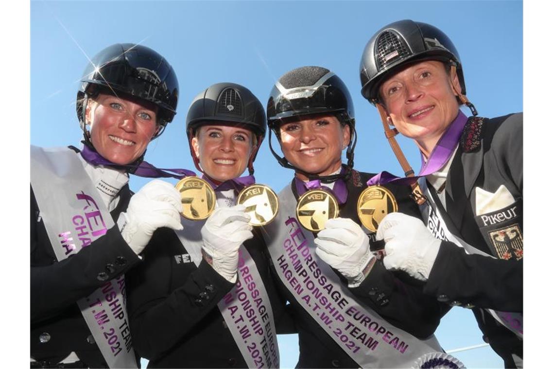 Die Dressurreiterinnen Helen Langehanenberg (l-r), Jessica von Bredow-Werndl, Dorothee Schneider und Isabell Werth mit ihren Goldmedaillen. Foto: Friso Gentsch/dpa