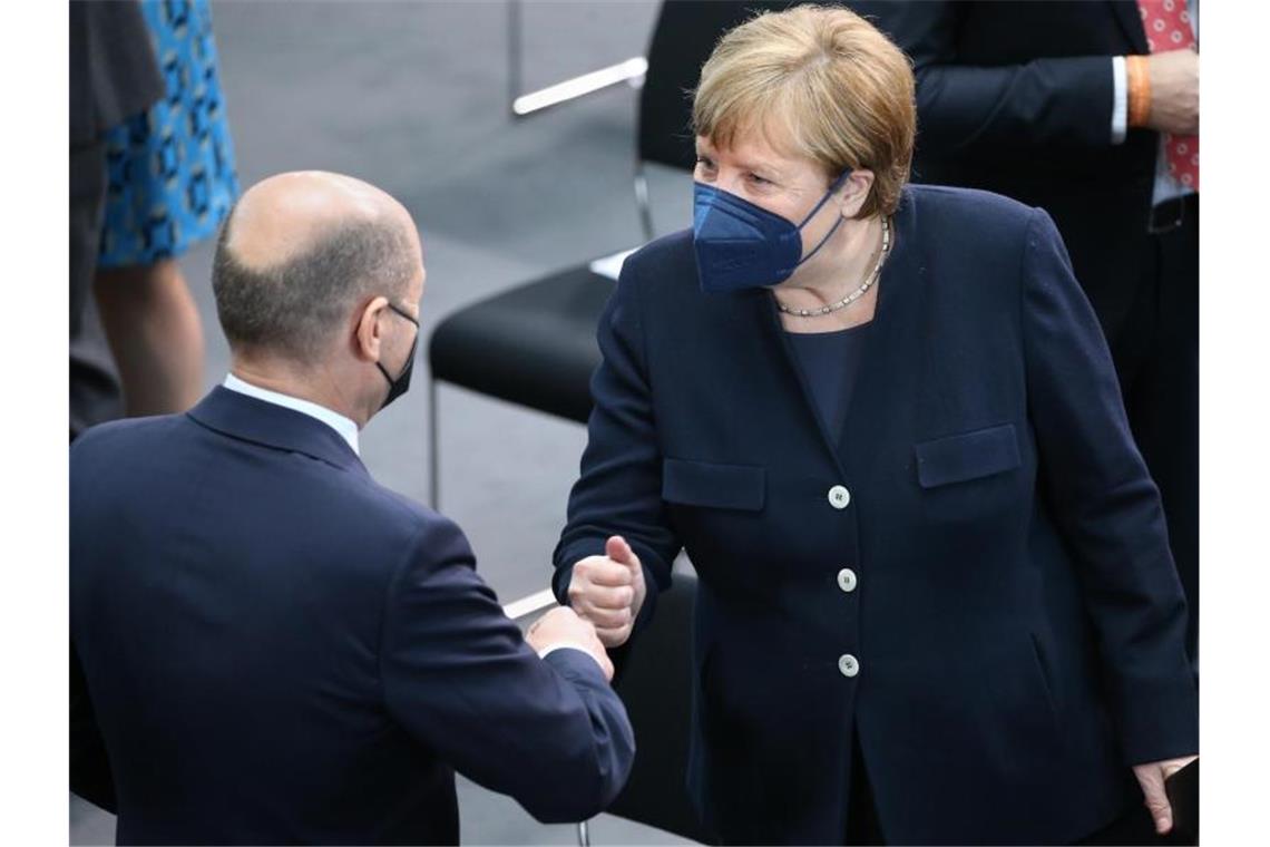 Die ehemalige Kanzlerin Angela Merkel (r.) begrüßt den amtierenden Kanzler Bundeskanzler Olaf Scholz. Foto: Wolfgang Kumm/dpa