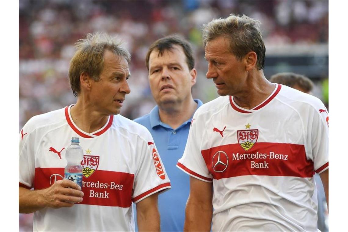 Die ehemalige Spieler des VFB, Jürgen Klinsmann (l) und Guido Buchwald unterhalten sich nach einem Legendenspiel. Foto: Marijan Murat/Archivbild
