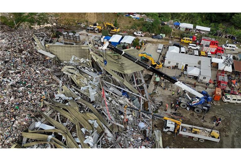 Die Einsatzkräfte suchen unter anderem mit einem Kran in den Abfall-Massen.